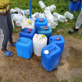 Voluntarios de la Asociación Asnuci junto con otros voluntarios residentes abastecen de agua potable en los asentamientos chabolistas de Lepe. Foto: Asnuci.