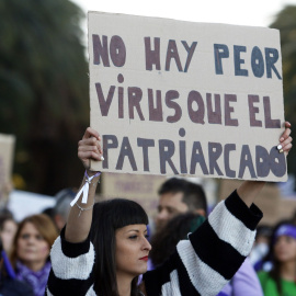 Una mujer sostiene una pancarta en la que se lee 'No hay peor virus que el patriarcado' durante la marcha por el Día Internacional de la Mujer en Málaga, en 2020. EUROPA PRESS/Álex Zea