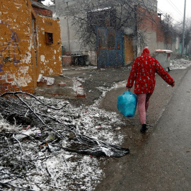 Una vecina del asentamiento de la Cañada Real camina bajo la nieve. EFE/Mariscal