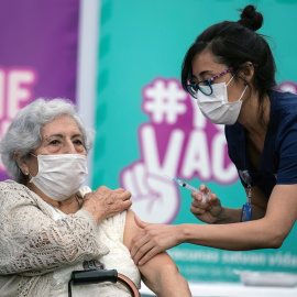 Una enfermera vacuna a una mujer en Chile. EPA-EFE