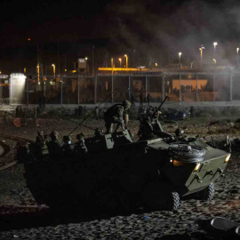  Un blindado del Ejército de Tierra maniobra en la playa del Tarajal para evitar la entrada de marroquíes que se lanzan para cruzar nadando la frontera.- JAIRO VARGAS