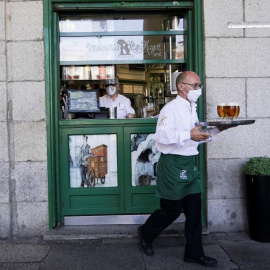  Un camarero con una bandeja con cervezas, en un bar junto a la Plaza Mayor de Madrid. REUTERS/Juan Medina