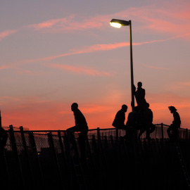 Chico subiéndose a una farola para poder saltar la valla. Foto: Teresa Palomo