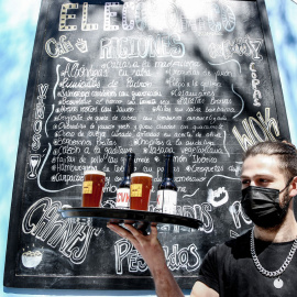  Un camarero lleva cervezas artesanales en una terraza, en uno de los bares que participan en ‘Artesana Week Lavapiés’, en la calle Argumosa, a 2 de abril de 2022, en Madrid (España).- EUROPA PRESS