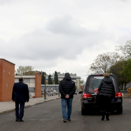 Familiares siguen el coche fúnebre con los restos de uno de los fallecidos por el coronavirus, en un cementerio de Madrid. REUTERS/Susana Vera