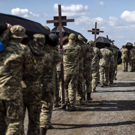  Soldados ucranianos cargan a hombros los ataúdes con los restos de sus compañeros, en un funeral y entierro colectivo celebrado hoy miércoles en el cementerio militar de Dnipro de veinticinco soldados muertos en el frente este de la guerra contra Rusi