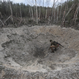 Un militar ucraniano inspecciona un agujero producido por un misil ruso cerca de Kiev (Ucrania). EFE/EPA/STR