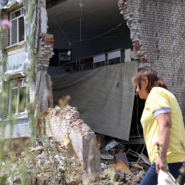  Una mujer pasa frente a una escuela parcialmente destruida como resultado de un ataque con misiles en la ciudad de Kostyantynivka, región de Donetsk, el 25 de julio de 2022.- AFP