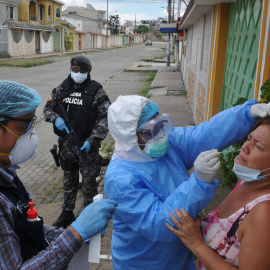  El personal del Ministerio de Salud prueba a una mujer para detectar COVID-19 en el complejo residencial Samanes 7 en el norte de Guayaquil, Ecuador, durante la pandemia de coronavirus, el 19 de abril de 2020.- Jose SANCHEZ / AFP