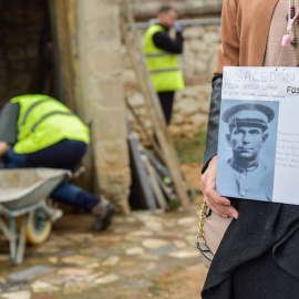  Una mujer muestra la imagen de su familiar asesinado en el cementerio de Guadalajara, a 1 de octubre de 2021.- EP