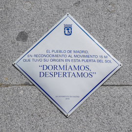  Placa con uno de los lemas ya clásicos del 15M, 'Dormíamos, despertamos', que luce en el número 10 de la Puerta del Sol desde hace dos años y medio, a 12 de mayo de 2021, en Madrid (España).- A. Pérez Meca / Europa Press