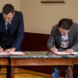 El presidente del Gobierno español en funciones, el socialista Pedro Sánchez, y el líder de Podemos, Pablo Iglesias, durante la firma en el Congreso de los Diputados de un acuerdo para la formación de un Ejecutivo de coalición. EFE/Paco Campos