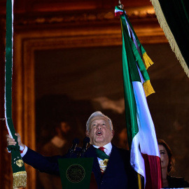  El presidente mexicano, Andrés Manuel López Obrador, ondea una bandera mexicana, flanqueado por su esposa Beatriz Gutiérrez, en el balcón principal del Palacio Nacional durante la ceremonia "El Grito" que marca el inicio de las celebraciones del Día