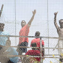  Varios migrantes detrás de una valla en la Ciudad del Fútbol del Altos del Real a 18 de mayo de 2021, en Melilla (España).-Ángela Ríos / Europa Press 