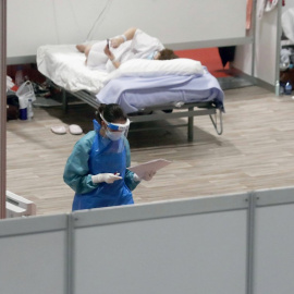 01/04/2020.- Una sanitaria trabaja en el pabellón 9 del centro de exposiciones Ifema, reconvertido en hospital temporal, durante la puesta en marcha de las primeras UCIs, este miércoles, en Madrid. EFE/J.J. Guillen