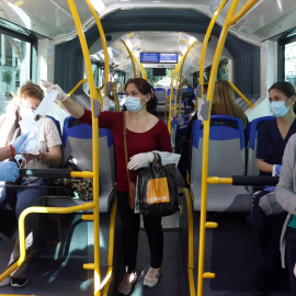  Miembros de protección civil de Málaga entregan mascarillas a los pasajeros de autobuses, durante la fase 0 de la desescalada del Gobierno en el inicio de la semana 8 del estado de alarma.- EUROPA PRESS