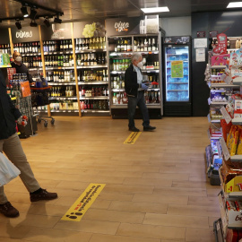 Clientes, con mascarillas, guardan la distancia social esperando a pasar por caja de un supermercado Dia&Go, del Grupo Dia, en Madrid. REUTERS/Susana Vera