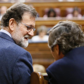 El presidente del Gobierno, Mariano Rajoy (i), conversa hoy con el portavoz del Partido Popular en el Congreso de los Diputados, Rafael Hernando, durante el pleno de hoy en la Cámara Baja, en el que se ha aprobado el real decreto ley de reforma de la est