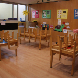 Una aula de la Llar d'infants municipal Els Minairons de la Seu d'Urgell totalment buida i amb diversos grups de taules amb les cadires al damunt. Albert Lijarcio / ACN