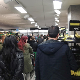 Decenas de personas esperan a pagar su compra en un supermercado en Madrid. EFE/Juan Vargas