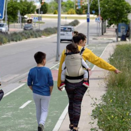 Una madre paseando con sus tres hijos. EFE