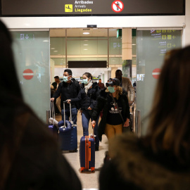 Pasajeros con mascarilla procedentes de Italia llegan al aeropuerto de Barcelona. - REUTERS