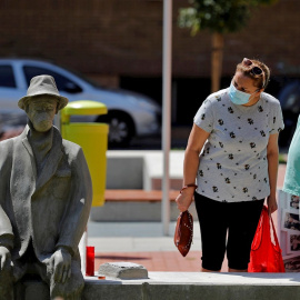Dos personas observan una escultura, de autor desconocido, en la pedanía valenciana de Benimamet, en recuerdo a los fallecidos por la Covid-19. EFE/Manuel Bruque