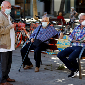 Tres hombres conversan en una plaza de Barcelona. EFE