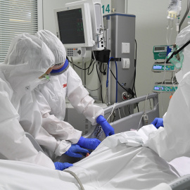 Pla mig dels sanitaris amb un pacient a la UCI de l'Hospital de Manresa (Althaia). Imatge del 24 d'abril de 2020 (Horitzontal).  Foto en Alta