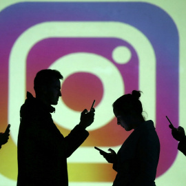  Siluetas de personas usando su 'smartphone' sobre un logo de la red social Instagram. REUTERS/Dado Ruvic/Illustration/