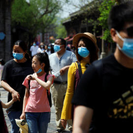 Personas con mascarilla en Beijing. REUTERS / Carlos Garcia Rawlins