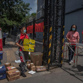 Un repartidor entrega paquetes para los residentes en un complejo residencial cerrado cerca del mercado de Yuquandong, en el distrito de Haidian, Pekín, China. EFE/EPA/ROMAN PILIPEY
