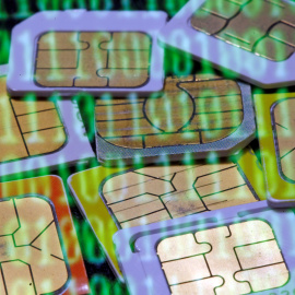 Tarjetas SIM reflejadas en una pantalla con código bonario. / REUTERS