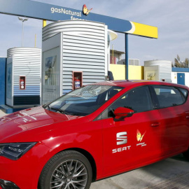 Un coche propulsado por gas permanece aparcado junto a una estación de repostaje. EFE