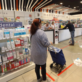Vista de una farmacia en Aluche (Madrid) este lunes . La capital, al igual que el resto de España, vive este lunes su primer día laboral de aplicación del decreto de alarma, que supone entre otras medidas la restricción de la movilidad, lo que disminu