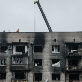  Los trabajadores reparan la parte superior de un apartamento quemado en la ciudad recientemente recuperada de Izyum, en la región de Donetsk, el 10 de octubre de 2022, en medio de la invasión rusa de Ucrania.Yasuyoshi CHIBA / AFP