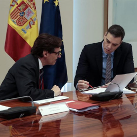 Fotografía facilitada por Moncloa que muestra al presidente del Gobierno, Pedro Sánchez (d) mientras conversa con el ministro de Sanidad, Salvador Illa (i) durante la videoconferencia de presidentes autonómicos tras haber anunciado una nueva prórroga 