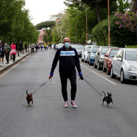 Un hombre pasea a sus perros en Roma. REUTERS/Remo Casilli