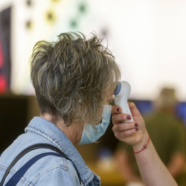 08/06/2020. -Una trabajadora le toma la temperatura a una clienta en el Centro comercial en Madrid. / EUROPA PRESS - RICARDO RUBIO