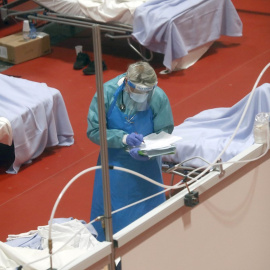 Personal sanitario trabaja en el pabellón 9 del centro de exposiciones Ifema, reconvertido en hospital temporal, durante la puesta en marcha de las primeras UCIs, este miércoles, en Madrid. EFE/J.J. Guillen