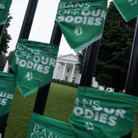 Mujeres atan pañuelos verdes en la valla de la Casa Blanca durante las protestas en contra de la decisión de la Corte Suprema sobre el aborto / REUTERS