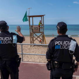 Efectivos policiales vigilan la playa de Can Pere Antoni de Palma. EFE/ CATI CLADERA