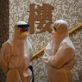 Dos personas, en un edificio de Hong Kong. (JEROME FAVRE | EFE)