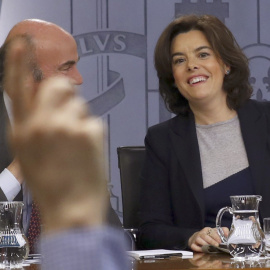 La vicepresidenta del Gobierno, Soraya Saénz de Santamaria, y el ministro de Economía, Luís de Guindos, durante la rueda de prensa posterior al Consejo de Ministros,  en el Palacio de La Moncloa. EFE/Sergio Barrenechea