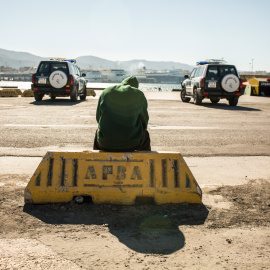 Un migrante descansa en el puerto de Algeciras, custodiado por la Guardia Civil tras ser rescatado por Salvamento Marítimo junto a potros migrantes a bordo de una patera.- JAIRO VARGAS