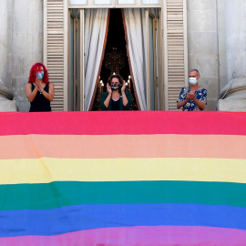La alcaldesa de Barcelona, Ada Colau (c), preside la colgada del pendón del arcoíris con motivo del Día del Orgullo y Liberación LGTBI, este domingo enelbalcón del Ayuntamiento de la ciudad. EFE/Quique Garcia