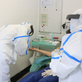 Professionals del CAP Manso, amb equip de protecció individual (EPI), en el moment d'extreure una mostra de sang amb una punxada al dit a una participant a l'estudi de seroprevalença del coronavirus a nivell estatal. 30 d'abril del 2020. (Horitzontal)
