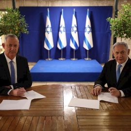 20/04/2020.- El primer ministro israelí, Benjamín Netanyahu (d), firma junto al centrista Beny Gantz (i) el acuerdo alcanzado este lunes mediante el cual Netanyahu seguirá siendo jefe de Gobierno israelí durante el primer año y medio de Ejecutivo uni
