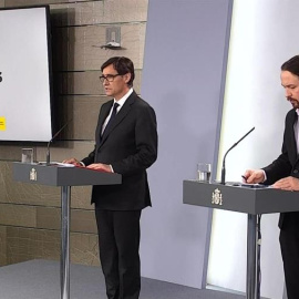 Captura de la señal institucional del Palcio de la Moncloa.- El vicepresidente de Asuntos Sociales y Agenda 2030, Pablo Iglesias (d), este jueves durante la rueda de prensa en el Palacio de la Moncloa, en la que ha comparecido junto al ministro de Sanida