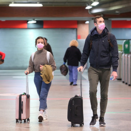 Viajeros con mascarilla en la estación de Atocha. EUROPA PRESS